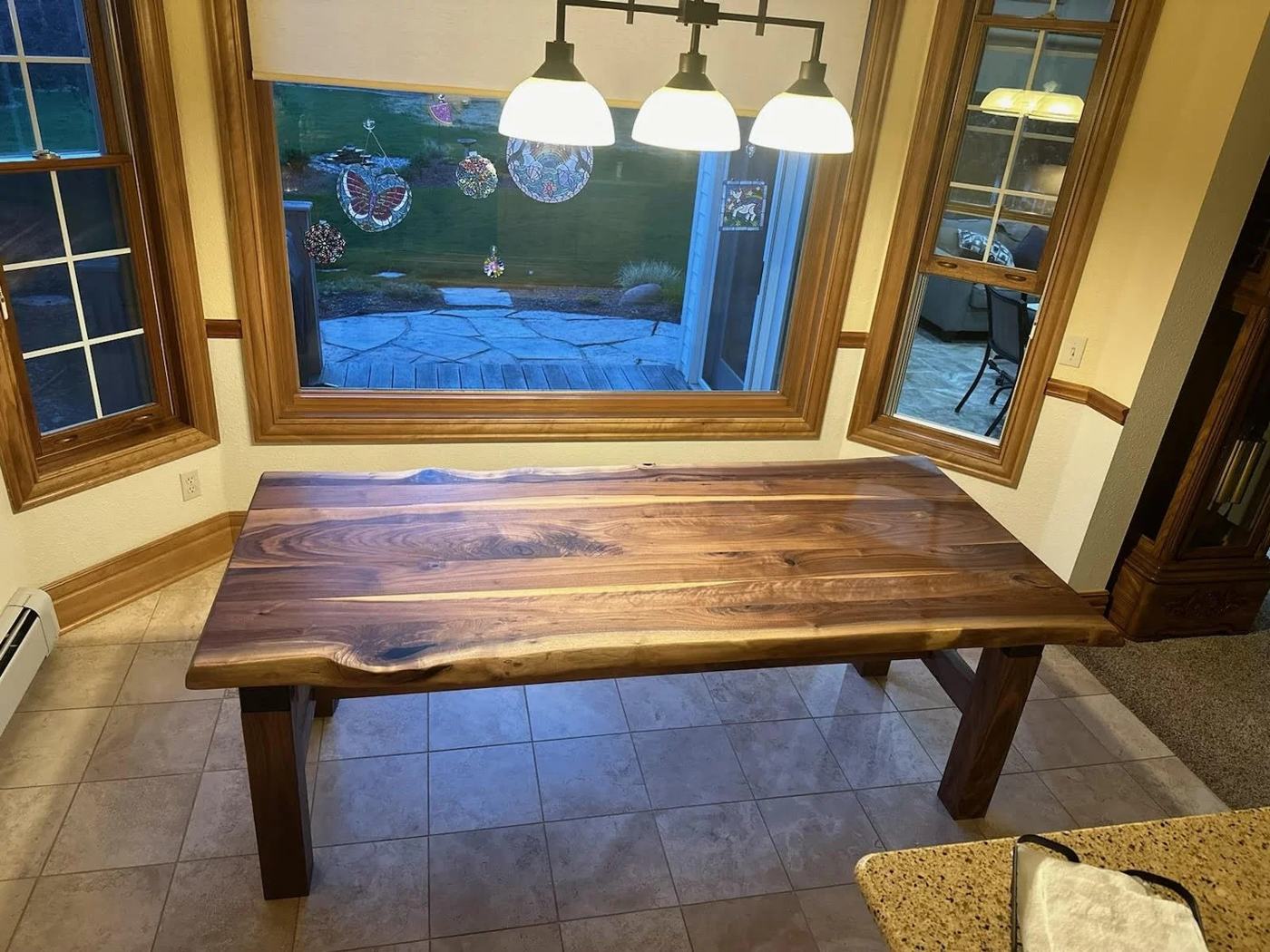 Live edge walnut slab table in a sunny breakfast nook