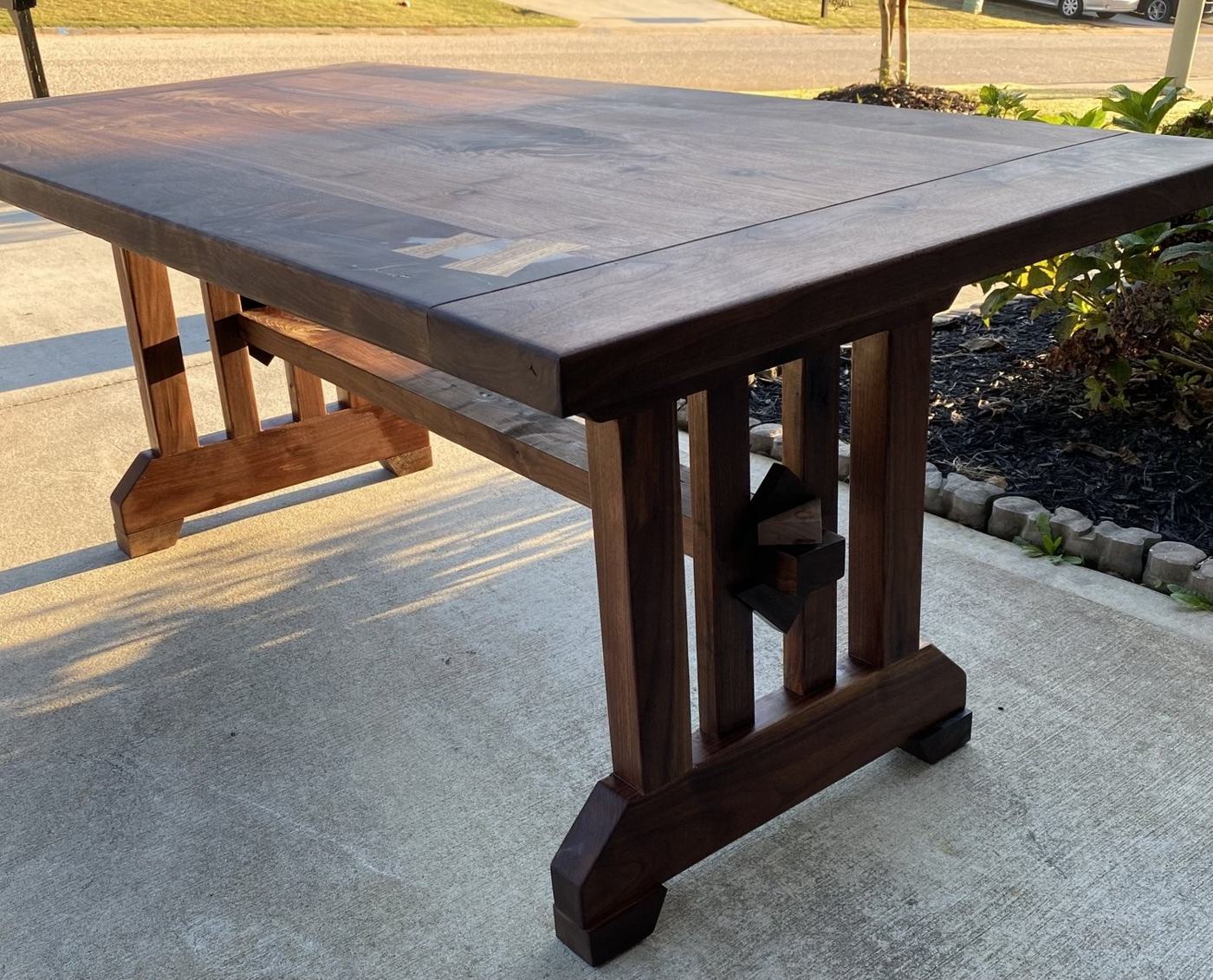 Walnut trestle table in evening light showing butterfly keys across the top